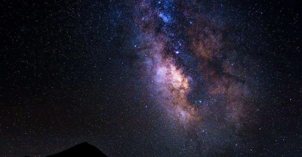 Captivating night sky featuring the Milky Way above silhouetted mountains in Onyx, California.