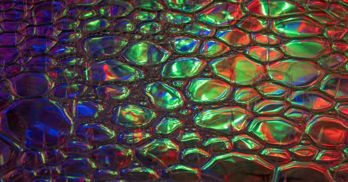 A colorful, abstract texture featuring vibrant reflections and holographic patterns. Ideal for creative backgrounds.
