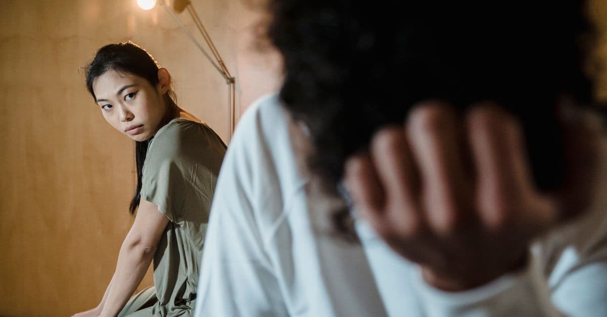 A couple experiencing tension and emotional crisis in a dimly lit room.