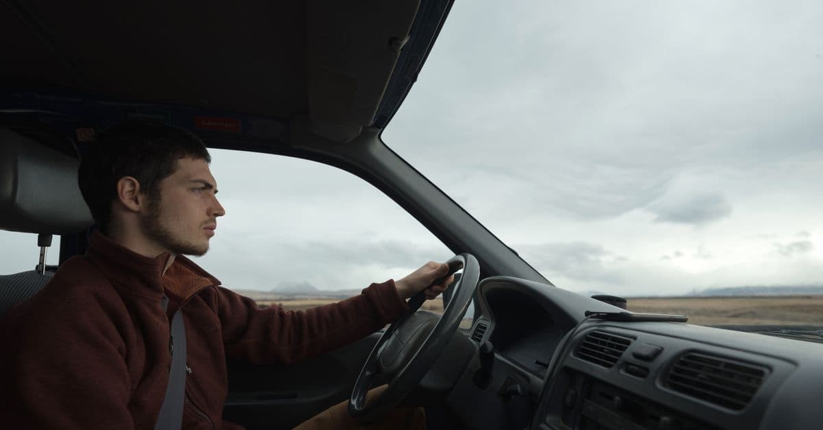 A man driving through a vast landscape, emphasizing solitude and exploration.