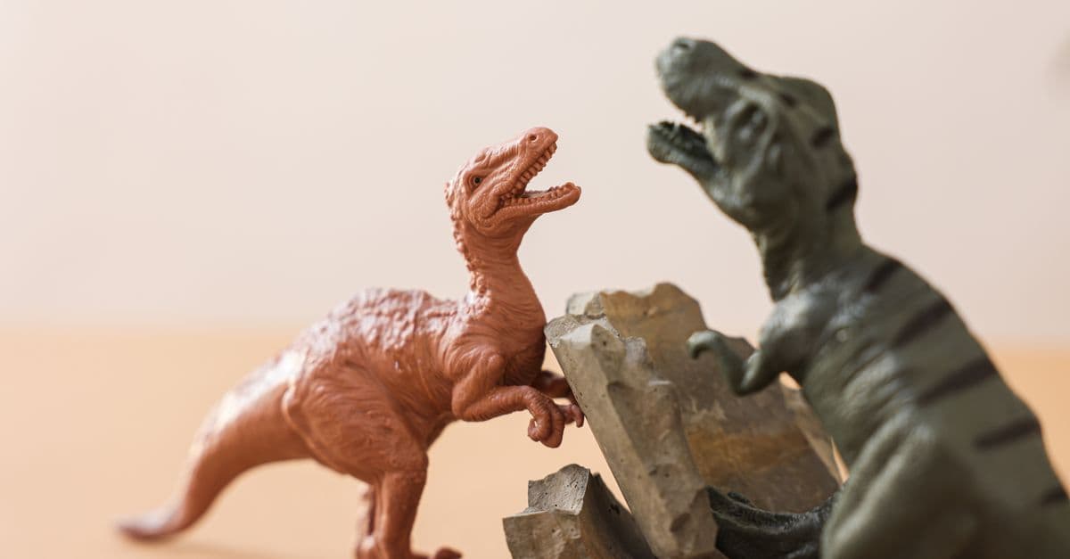 Close-up of colorful dinosaur figurine toys engaged in a playful battle.