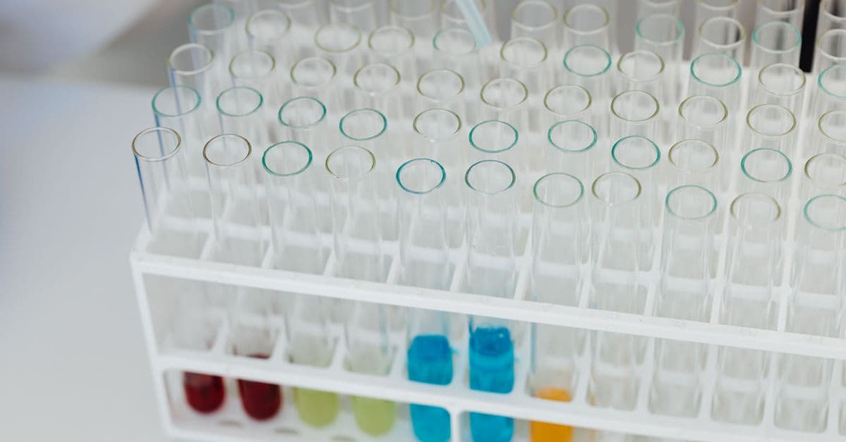 Close-up of a laboratory test tube rack with colorful chemical solutions, emphasizing scientific research.