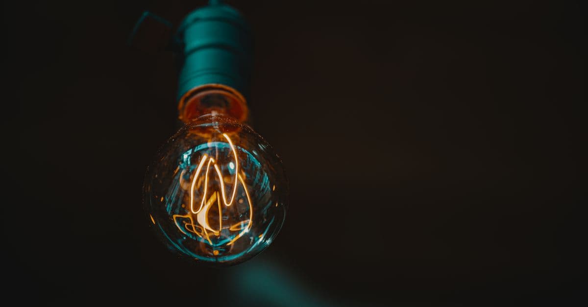 Close-up shot of a vintage Edison bulb glowing warmly in a dark setting.