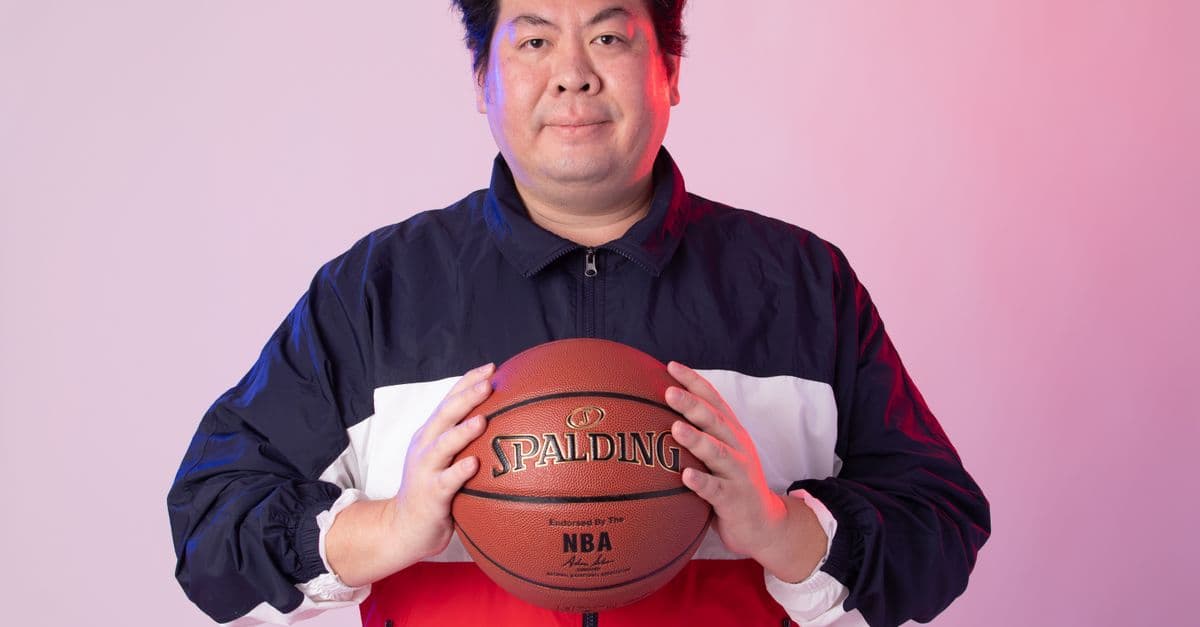 Man in sportswear with basketball against a gradient background.