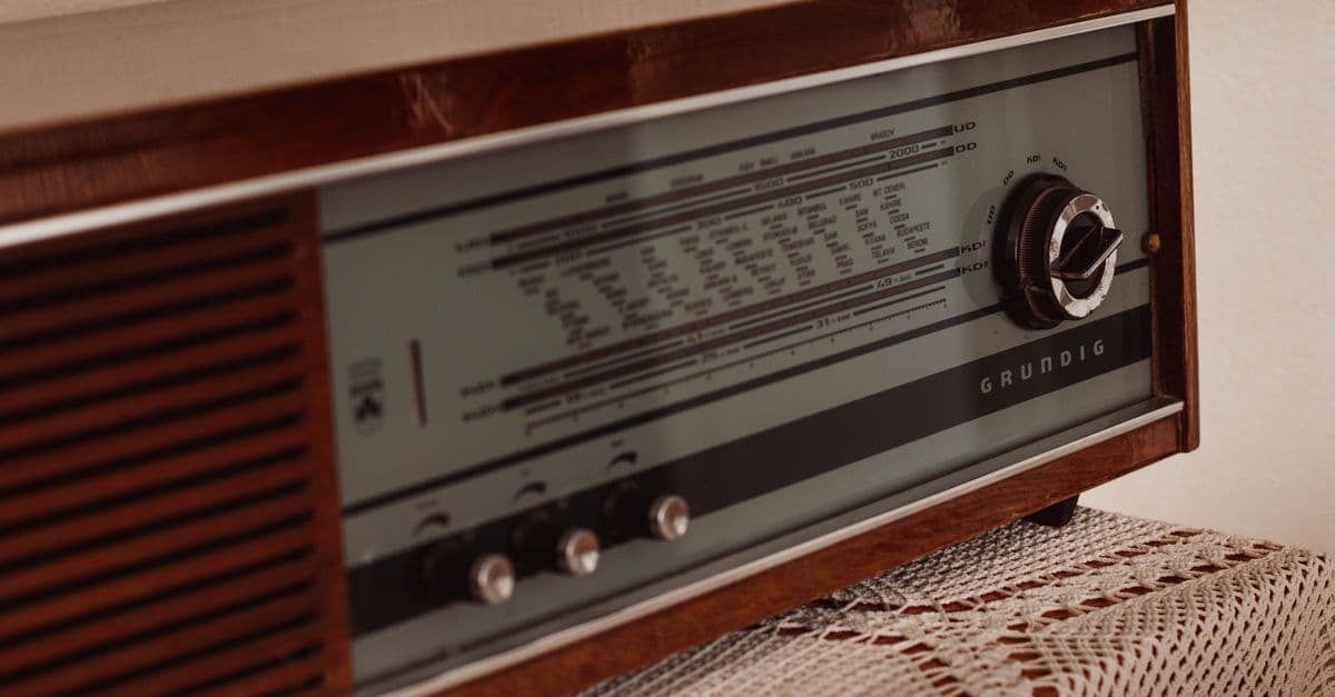 Control panel of vintage radio receiver placed on tablecloth on wooden table in old apartment