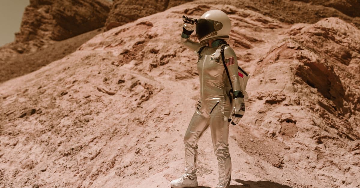Astronaut standing on a rocky terrain resembling Mars or Moon, pondering future space exploration.