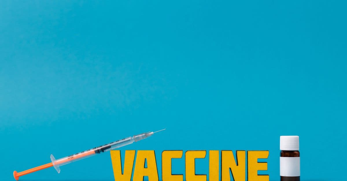 A bright image showcasing a syringe and vaccine bottle with the word 'Vaccine'.
