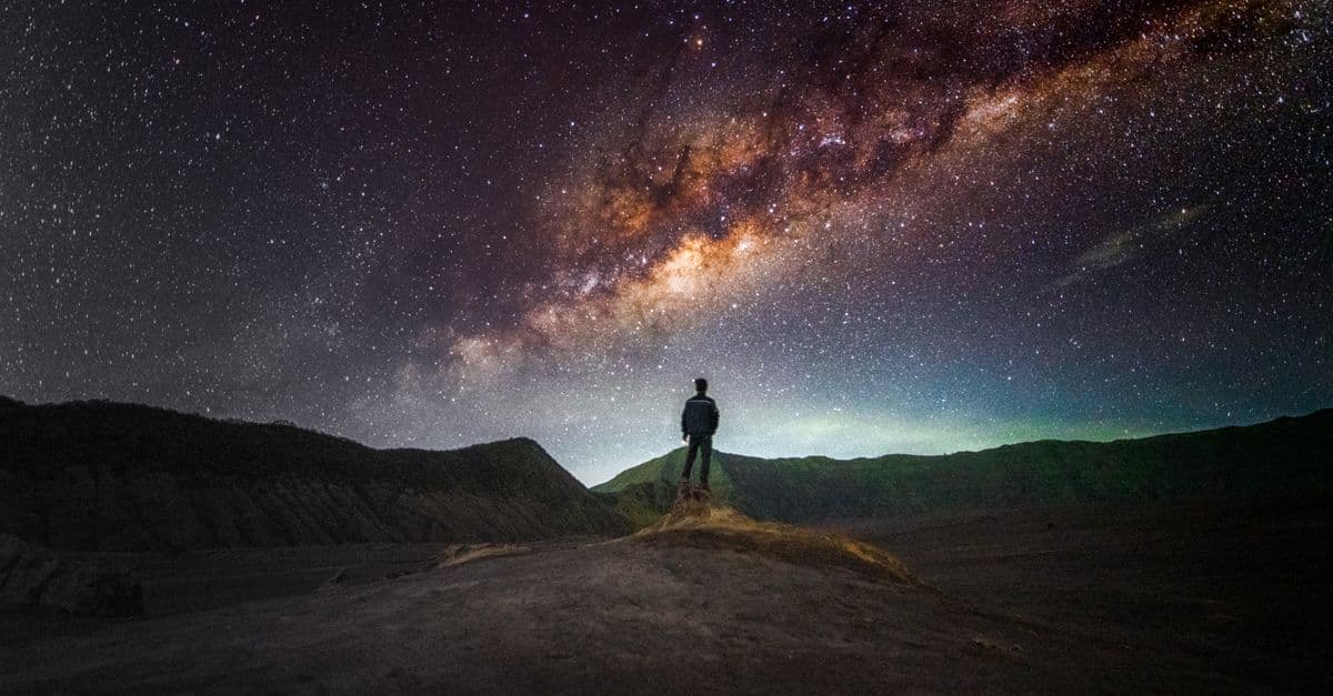Person silhouetted against stunning Milky Way galaxy in East Java, Indonesia, inspiring exploration.