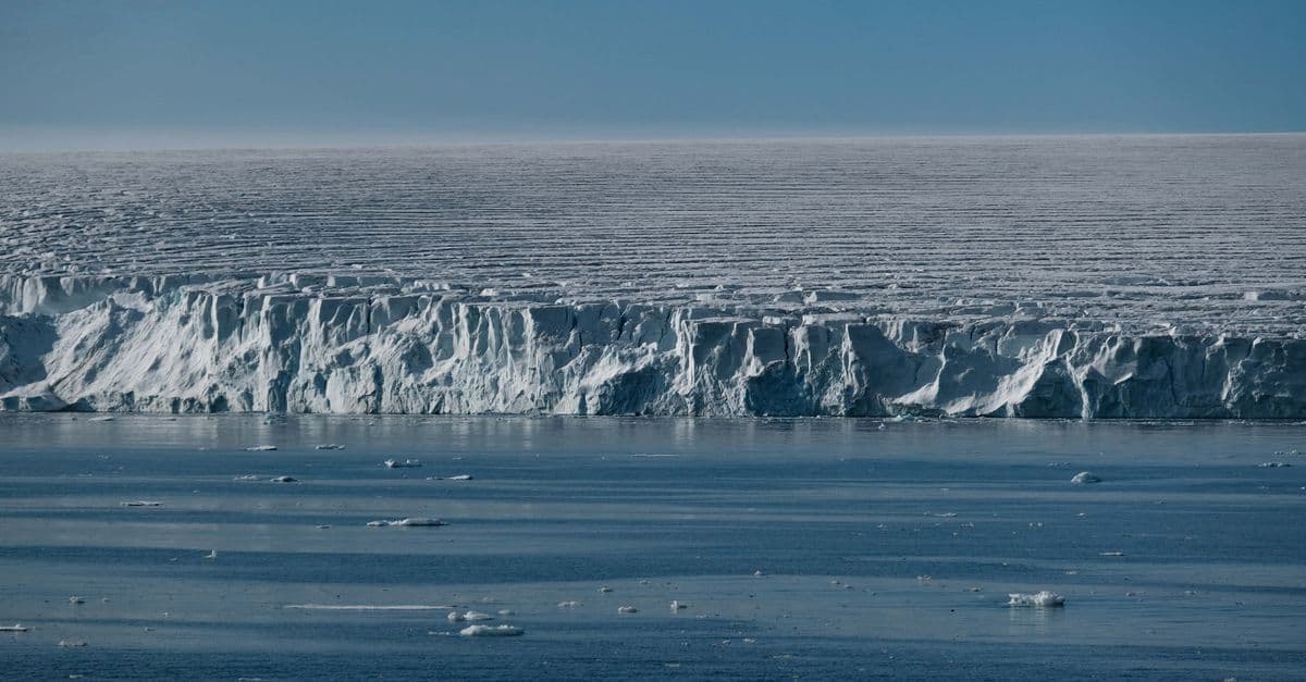 Stunning view of a vast ice shelf merging with the cold ocean waters, capturing nature's raw beauty.