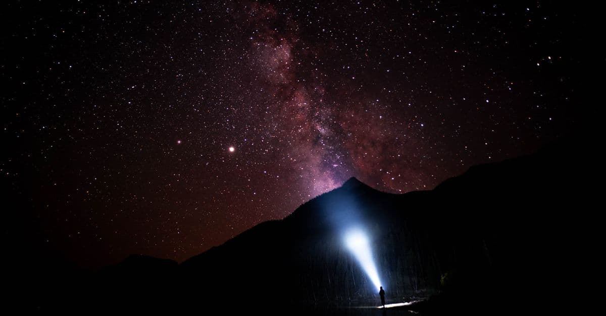 A person exploring the starry night sky at Yellowstone National Park, featuring the Milky Way.
