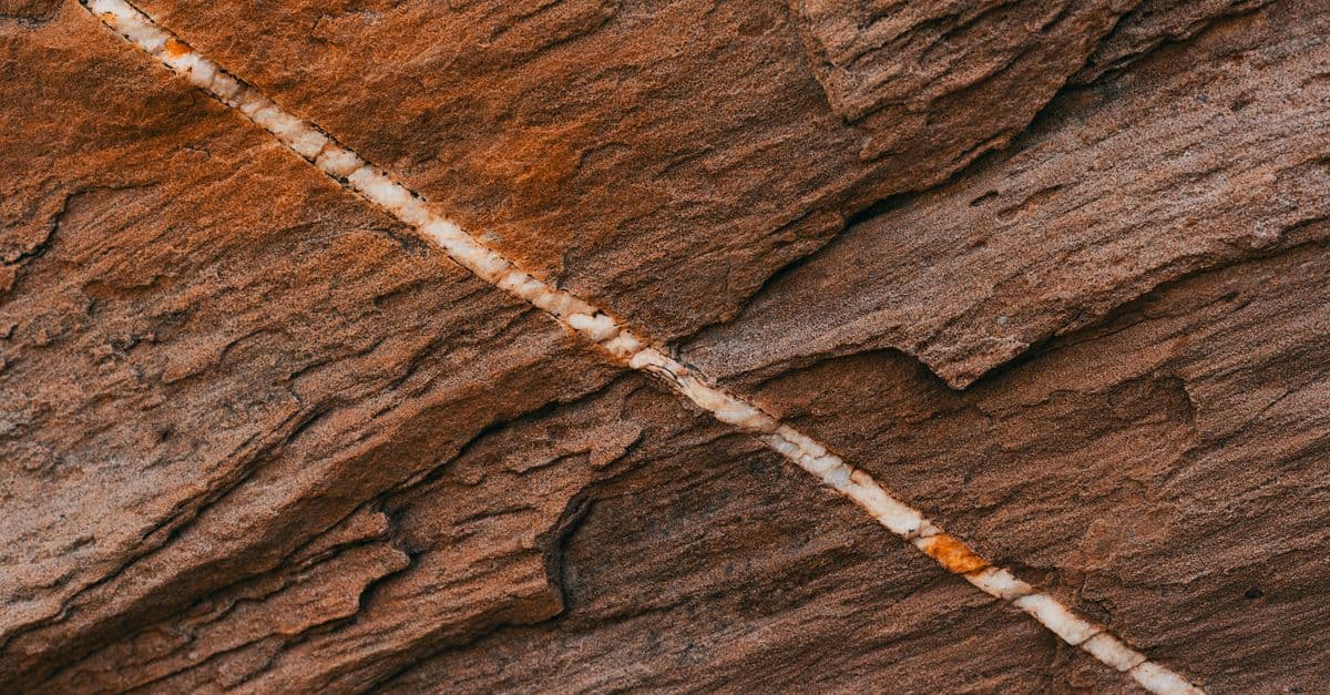 Detailed view of sedimentary rock featuring a prominent mineral vein across its surface.
