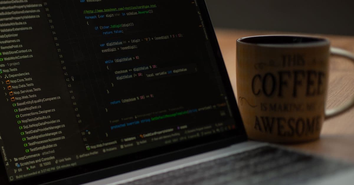 Close-up of a laptop screen with code and a coffee mug, perfect for tech abstract themes.