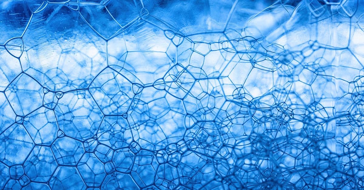 Detailed close-up of blue soap foam showcasing abstract geometric patterns and texture.