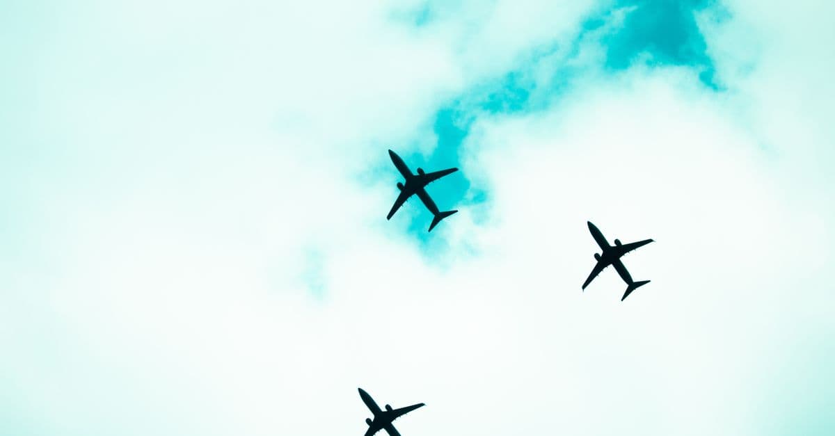 Silhouetted airplanes flying in formation against a bright sky. Captures the essence of aviation.