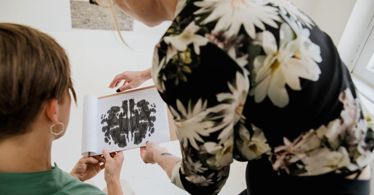 A therapist and patient analyze a Rorschach inkblot test in a counseling session.