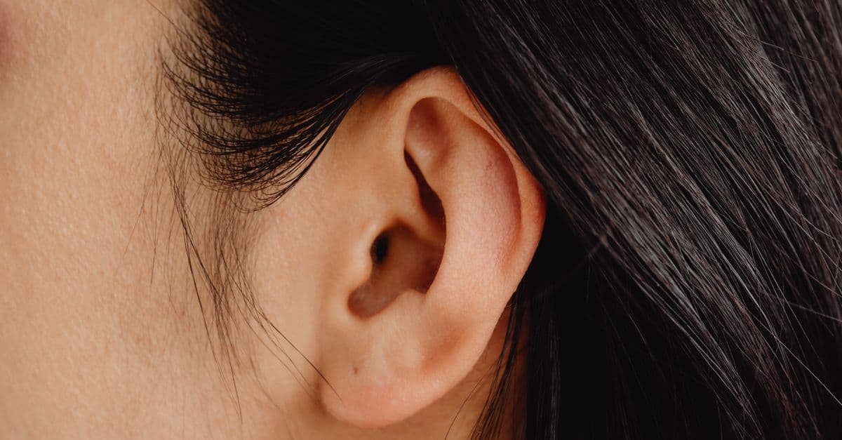 Detailed close-up photo showcasing a human ear with dark hair.