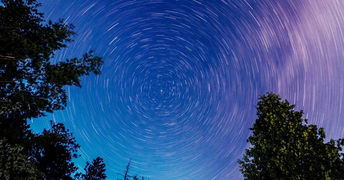 Beautiful long exposure of star trails creating a spiral effect over a forest in Barry's Bay, Ontario, Canada.
