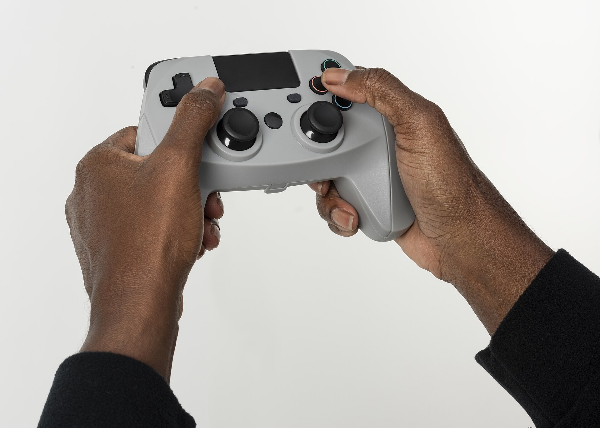Hands holding a video game controller, representing interactive digital games and game design.